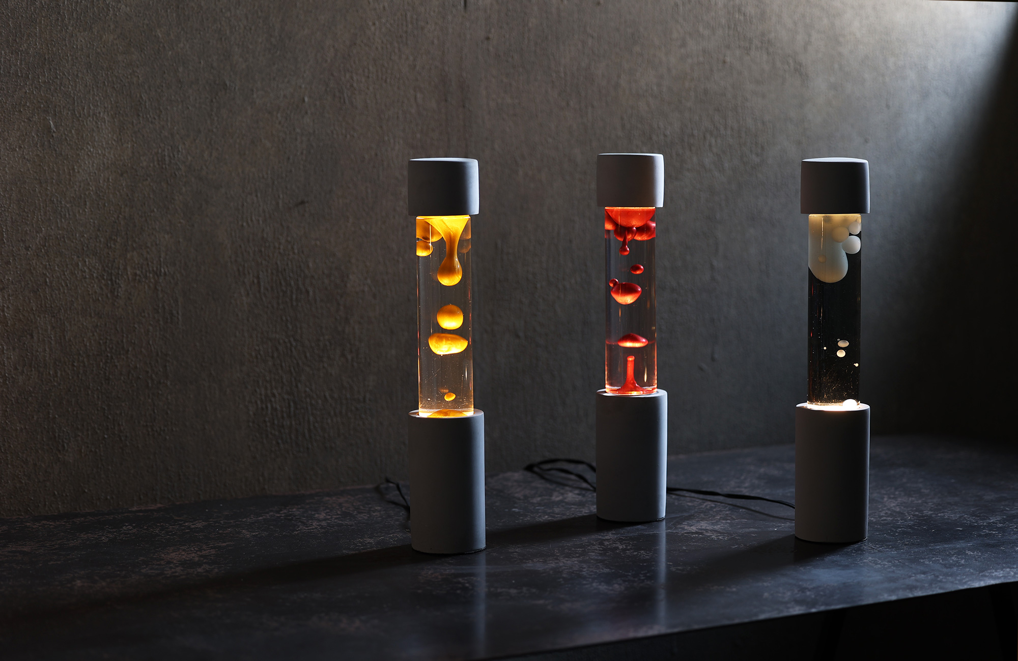 点灯すると呼吸をするように流動的に形を変えながらコンクリートの筒を行き来する Dripping Lamp（ドリッピングランプ）